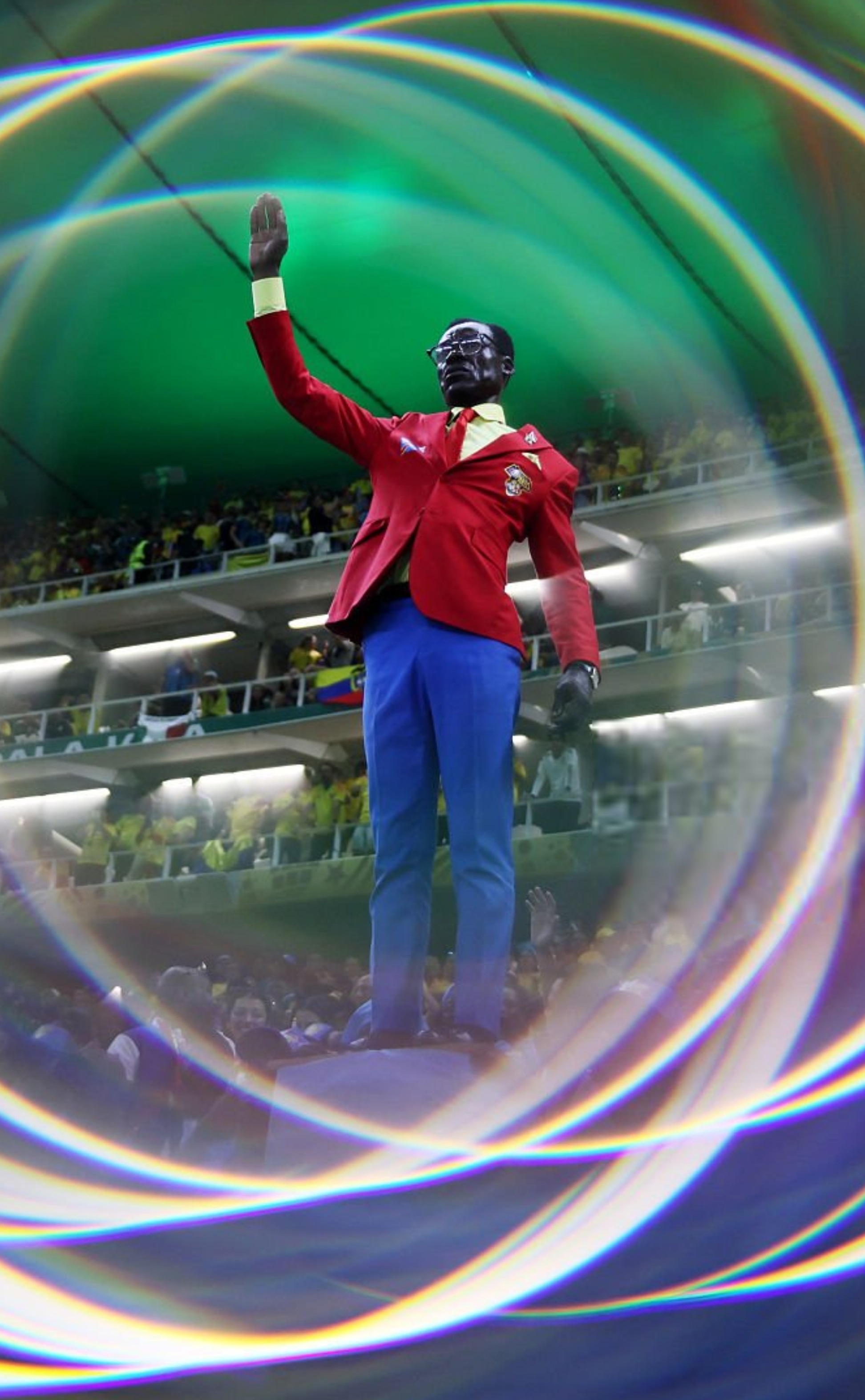 Michel Nkuka Mboladinga, the Congo DR supporter known for standing motionless as a tribute to independence leader Patrice Lumumba, attended his first FIFA World Cup match after missing earlier games due to quarantine and visa issues.